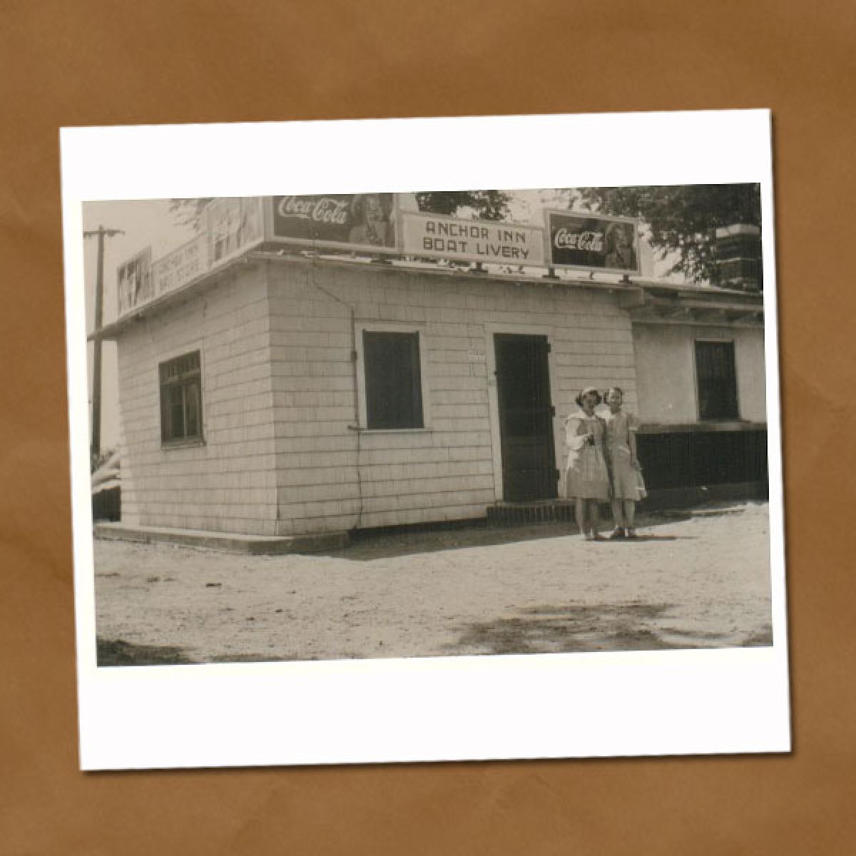 Black and white photo of old building with two young girls standing in front