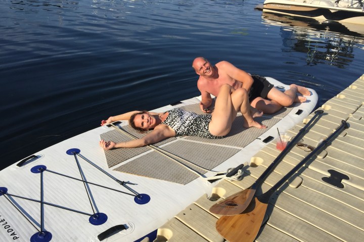 Mega sized stand up paddleboard with two people laying on it