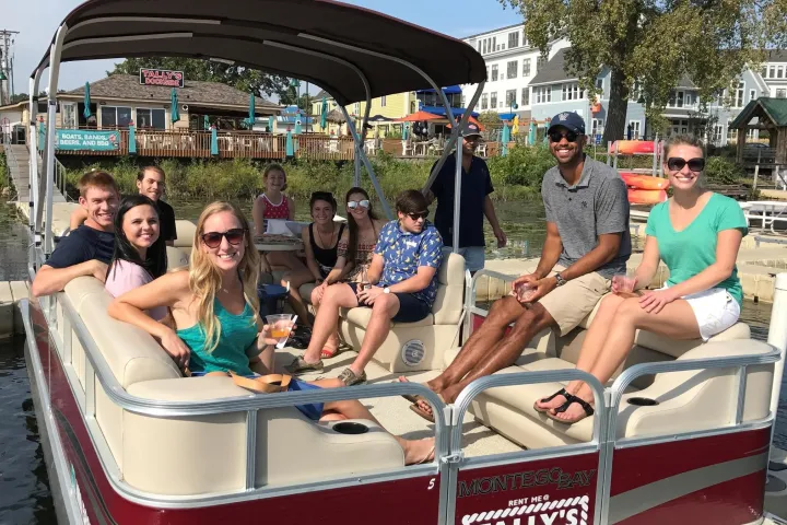 Group of people sitting in red pontoon boat
